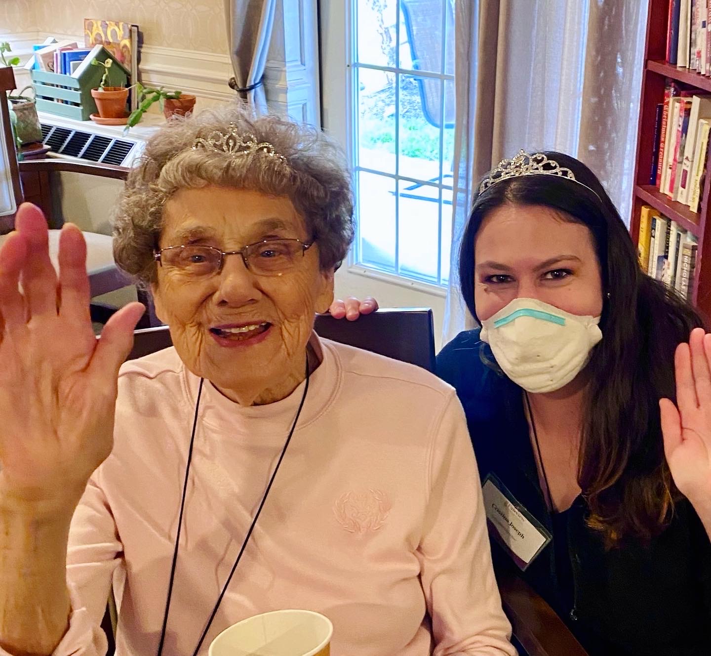 Resident and staff member smiling and waving