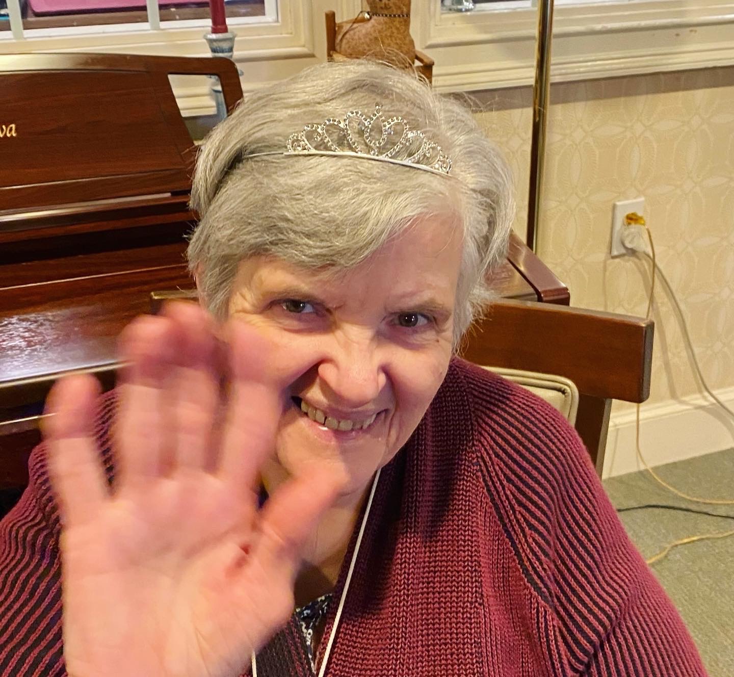 Resident waving with a smile in a communal area