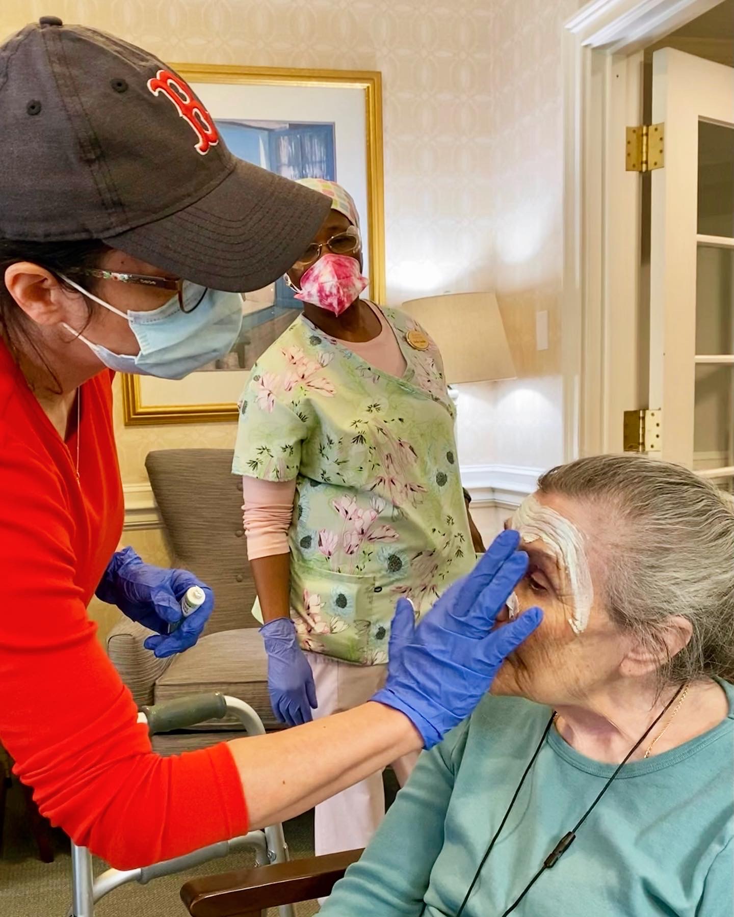 Staff member providing skincare treatment to a resident