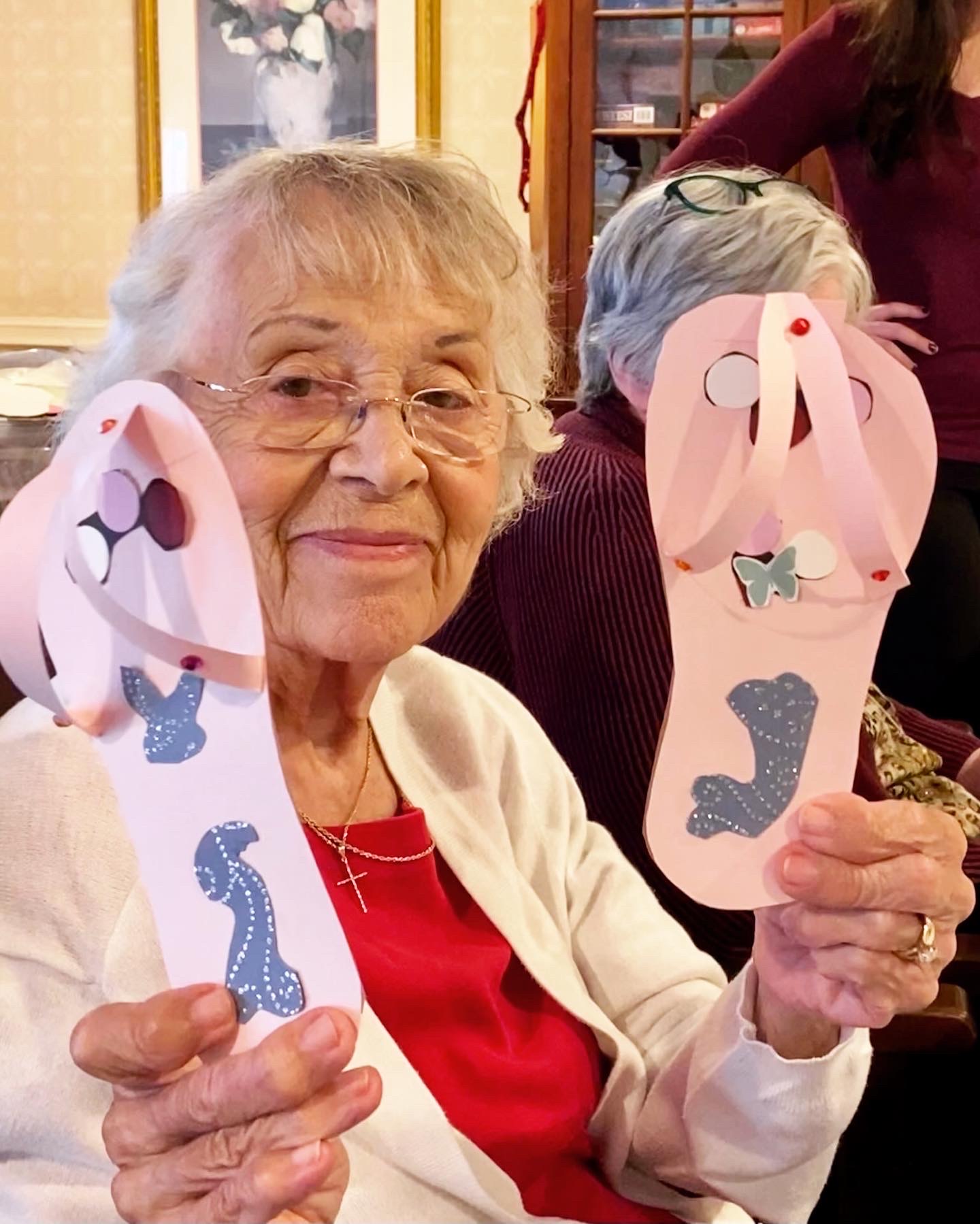 Resident holding handmade flip-flops during an activity