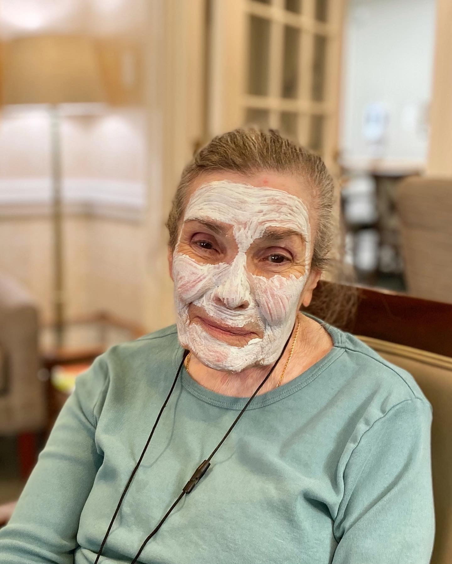 Resident enjoying a facial treatment in a lounge