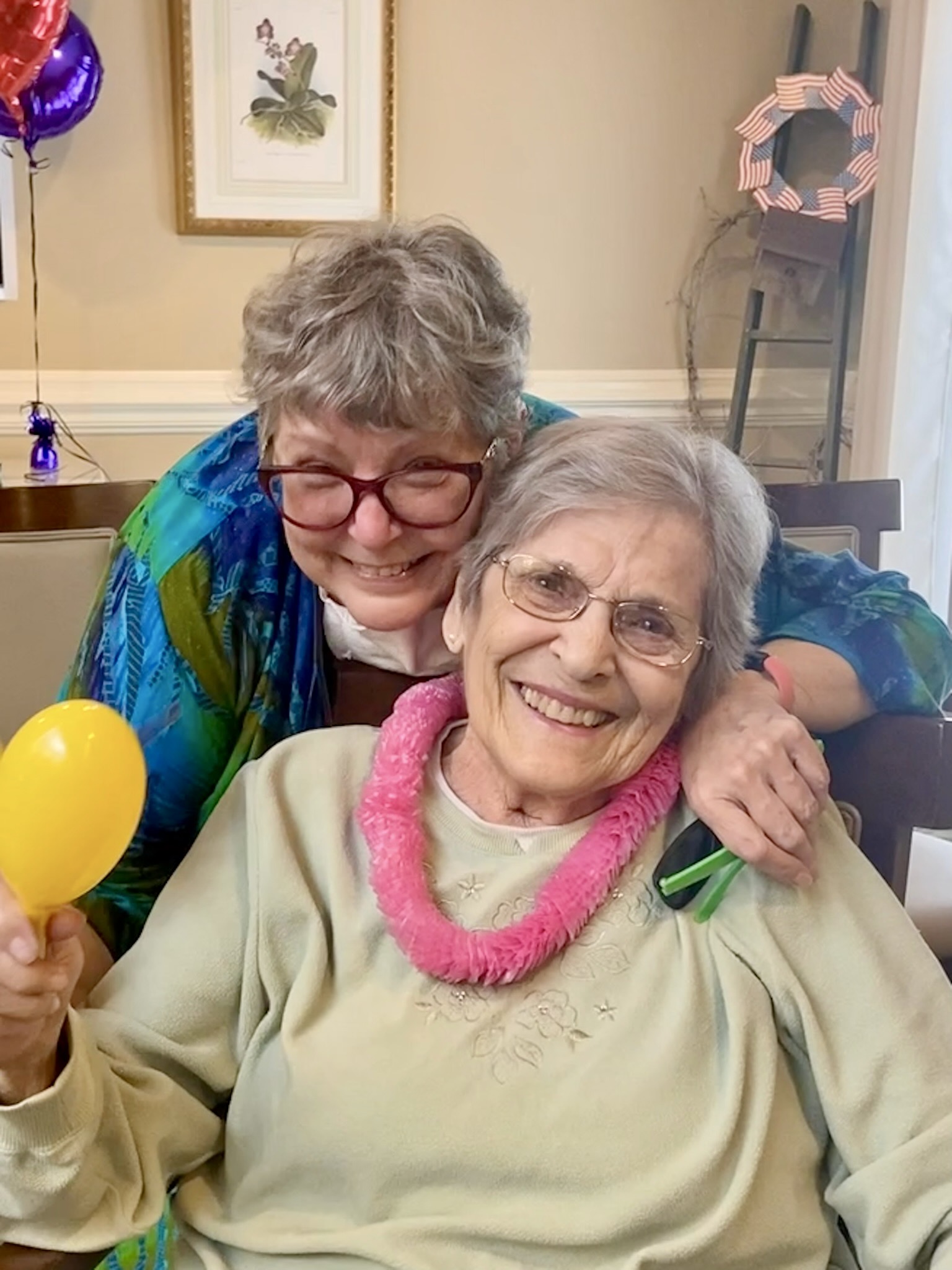 Smiling staff and resident celebrating together indoors
