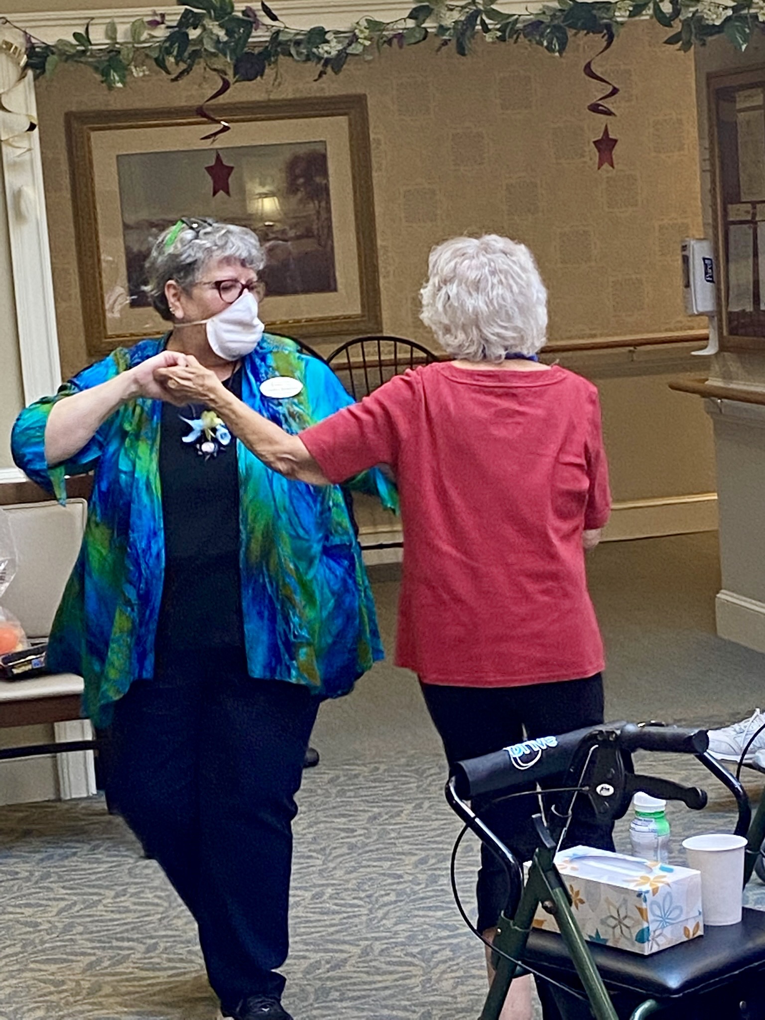 Staff member dancing with resident in common area