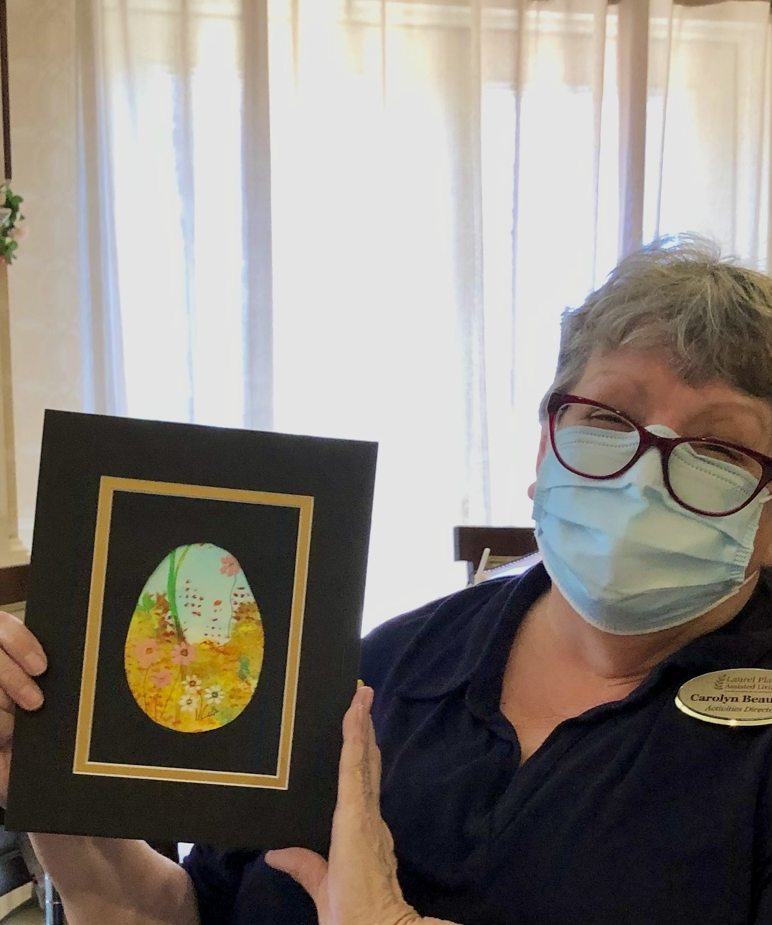Staff member holding a decorated art piece