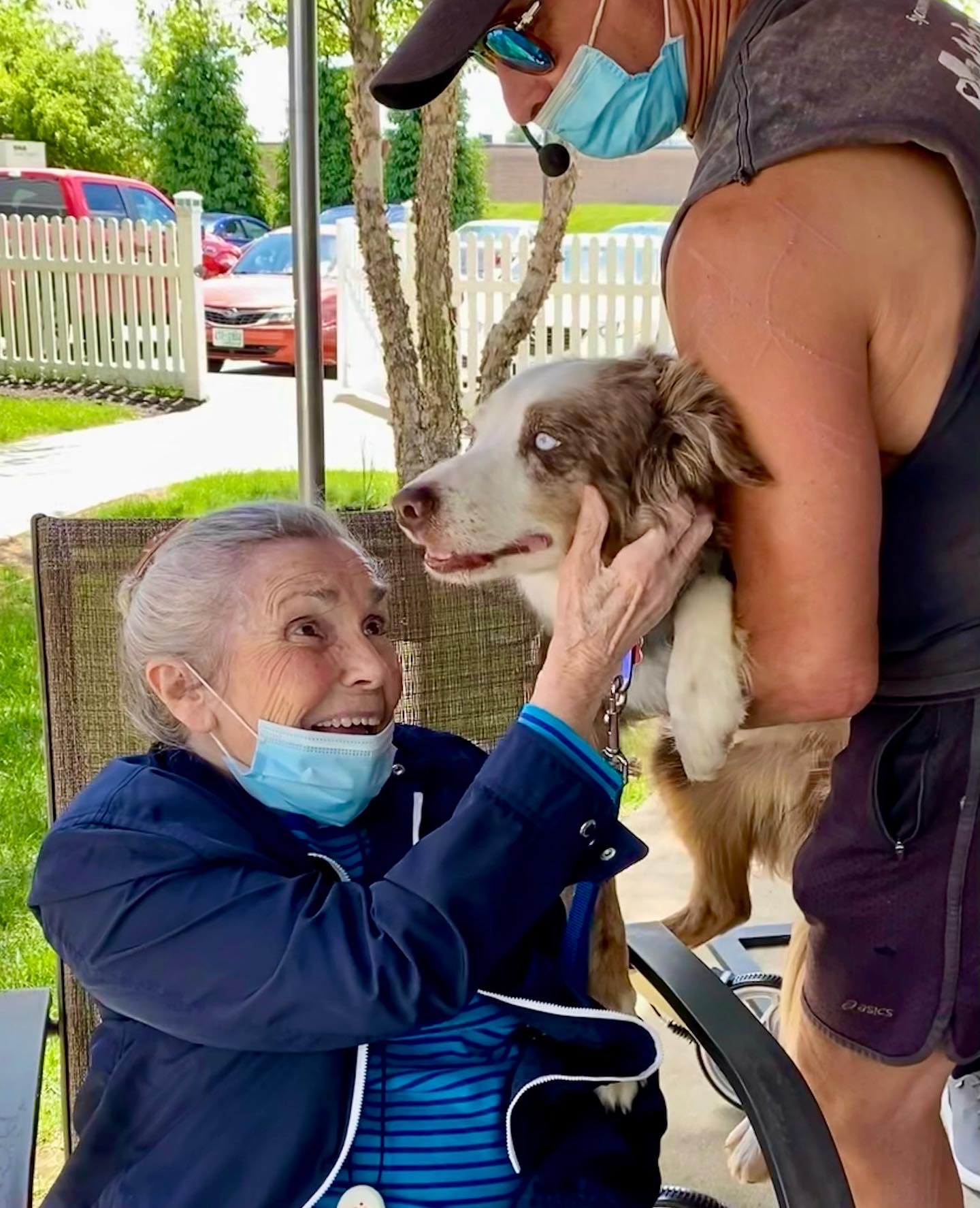 Senior resident interacting with a dog outside