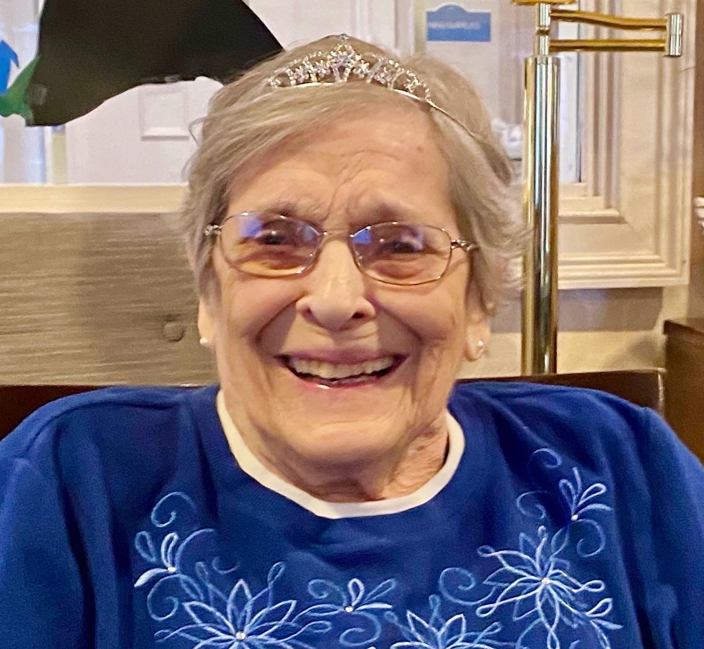 Smiling resident wearing a tiara in the common area