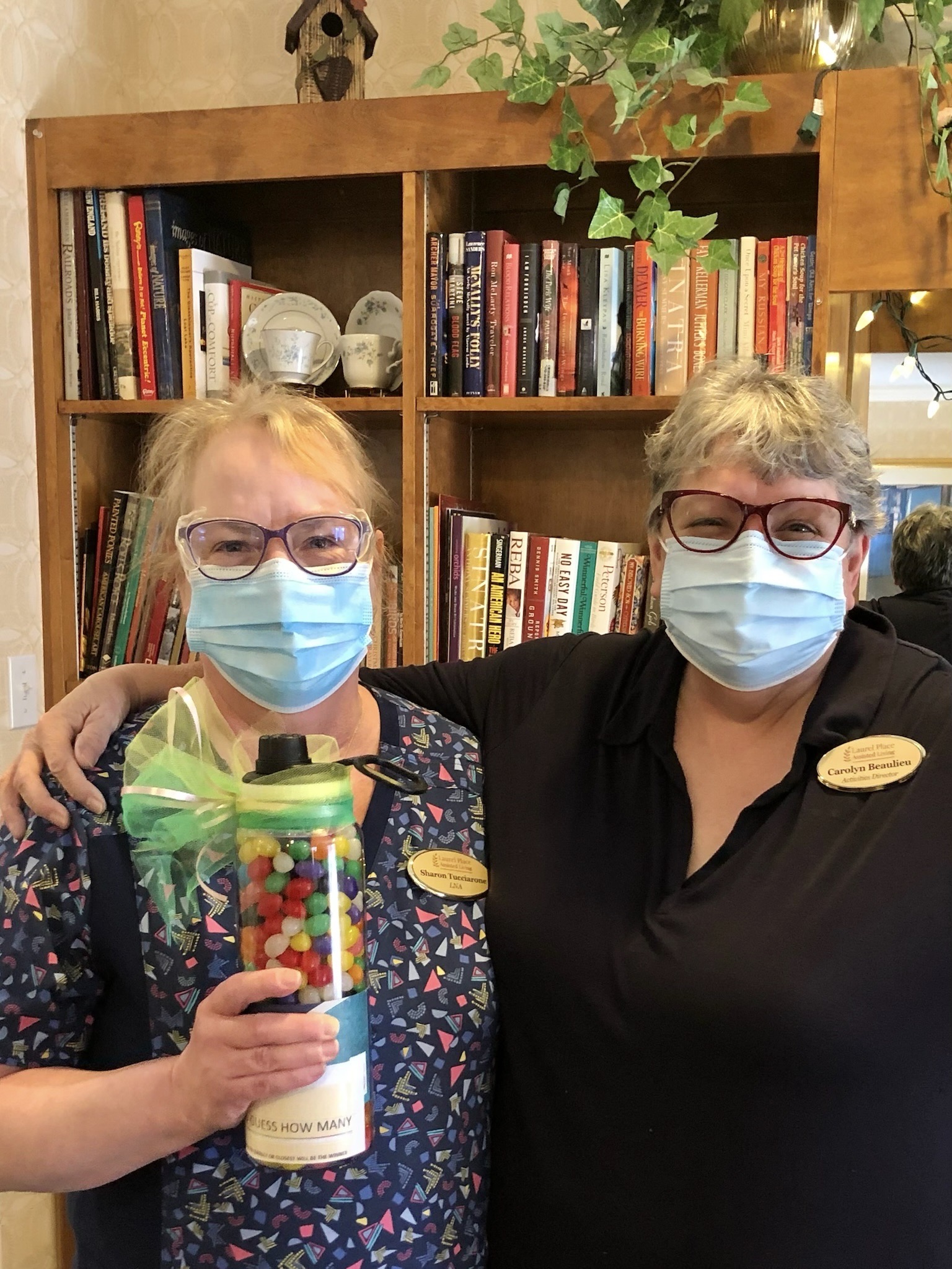 Two staff members smiling in a cozy library
