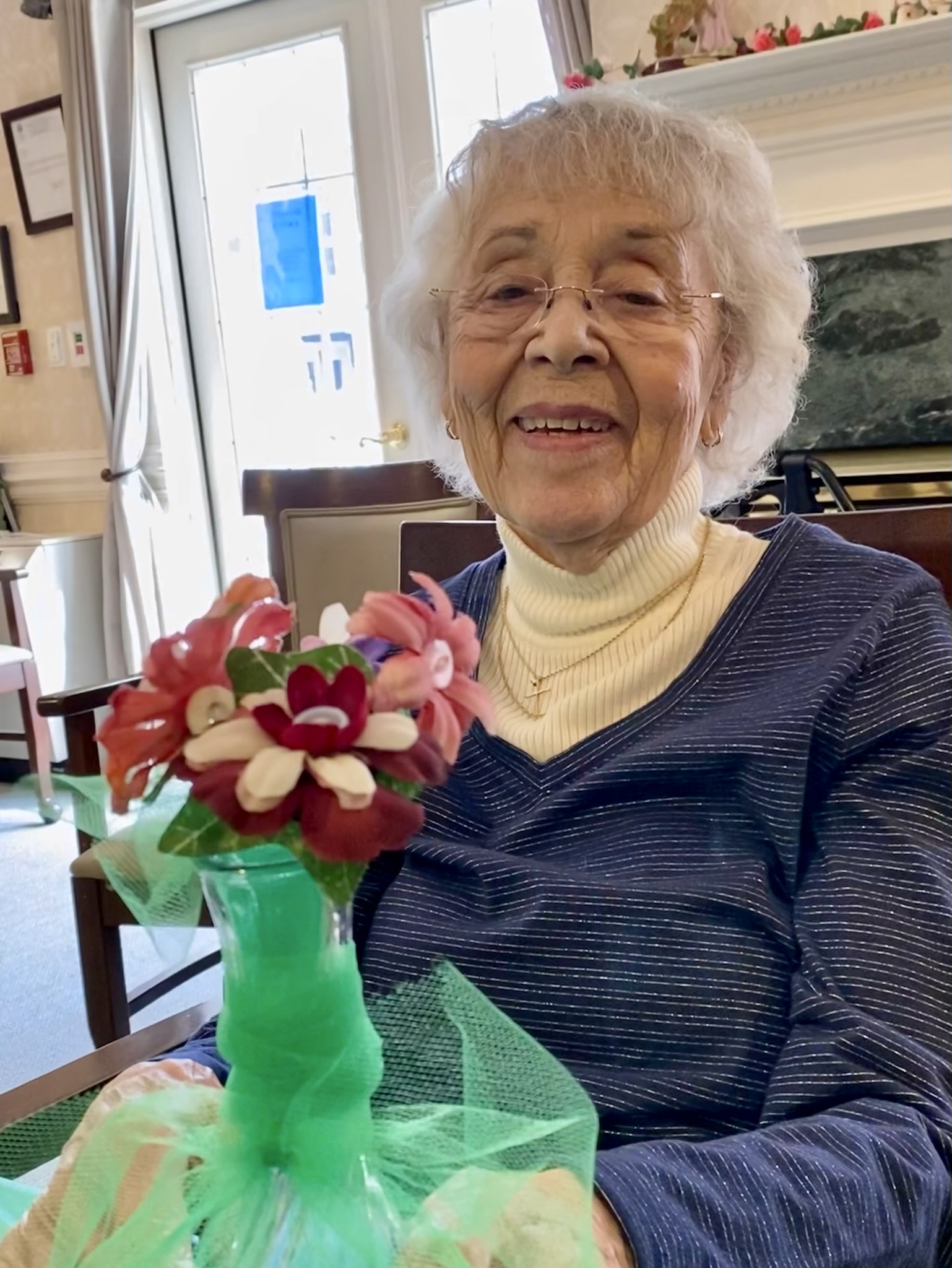 Resident holding a handmade flower arrangement in a common area