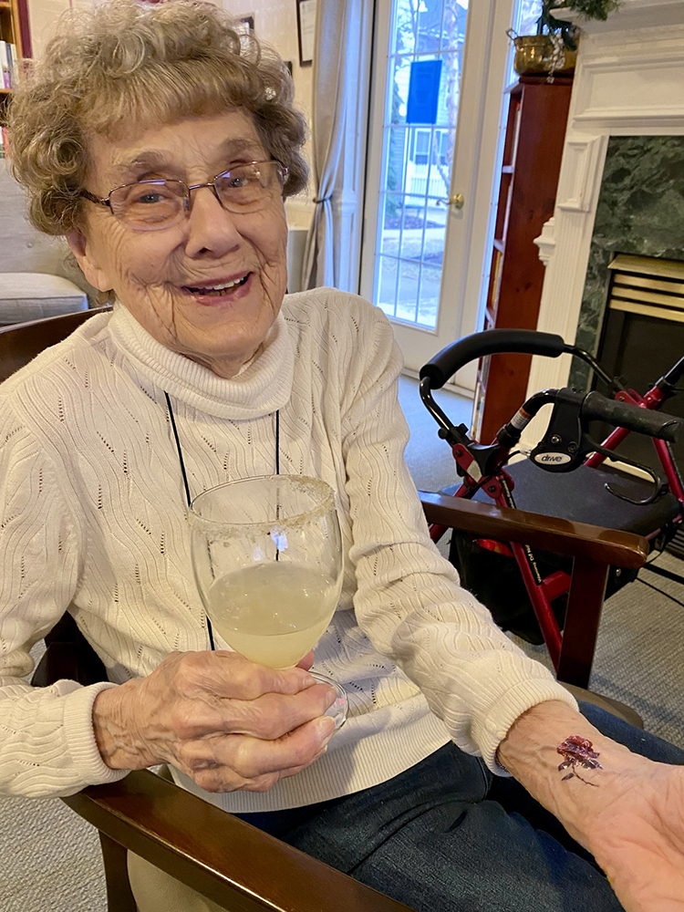 Senior resident enjoying a drink and smiling