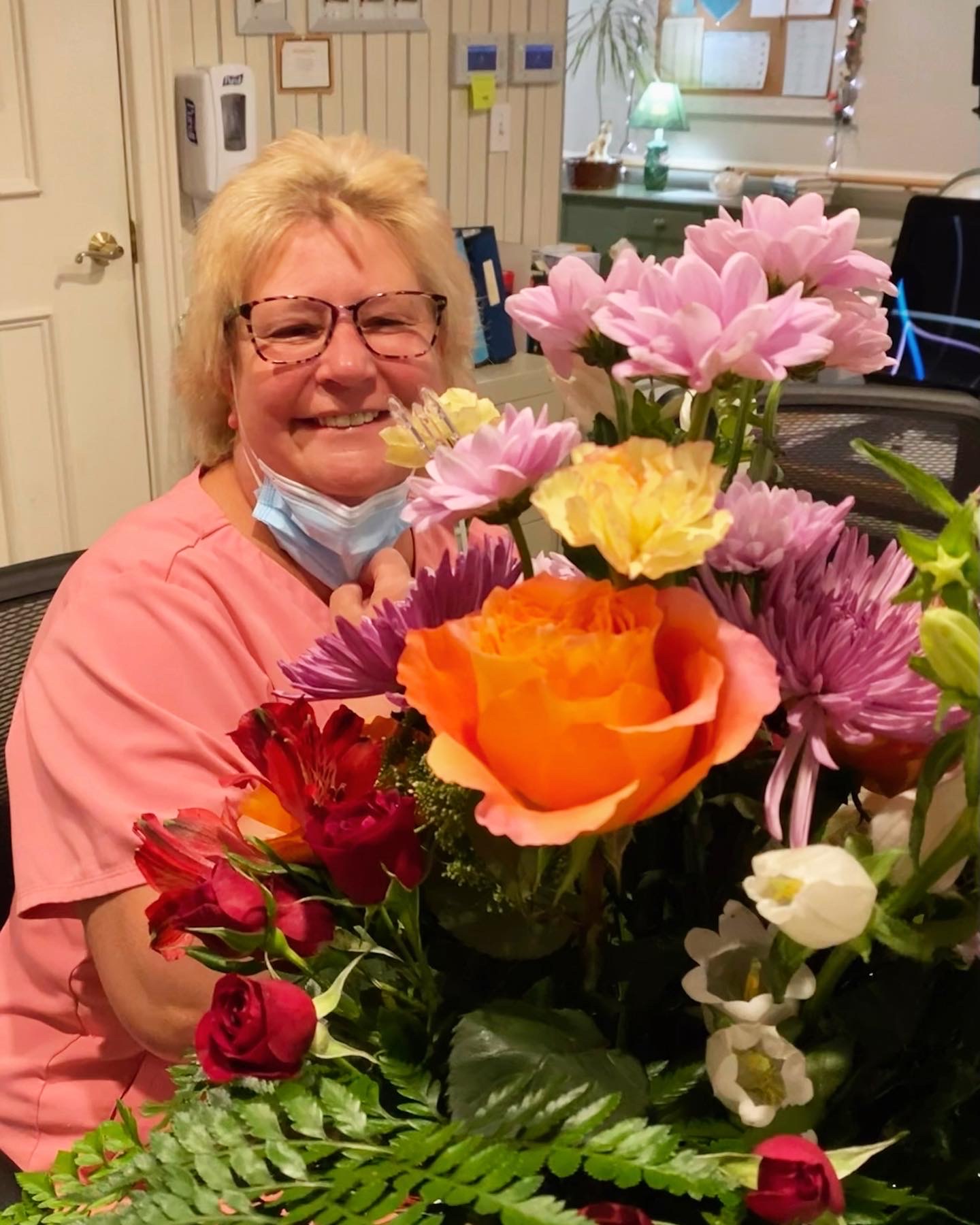Staff member smiling with a bouquet of flowers