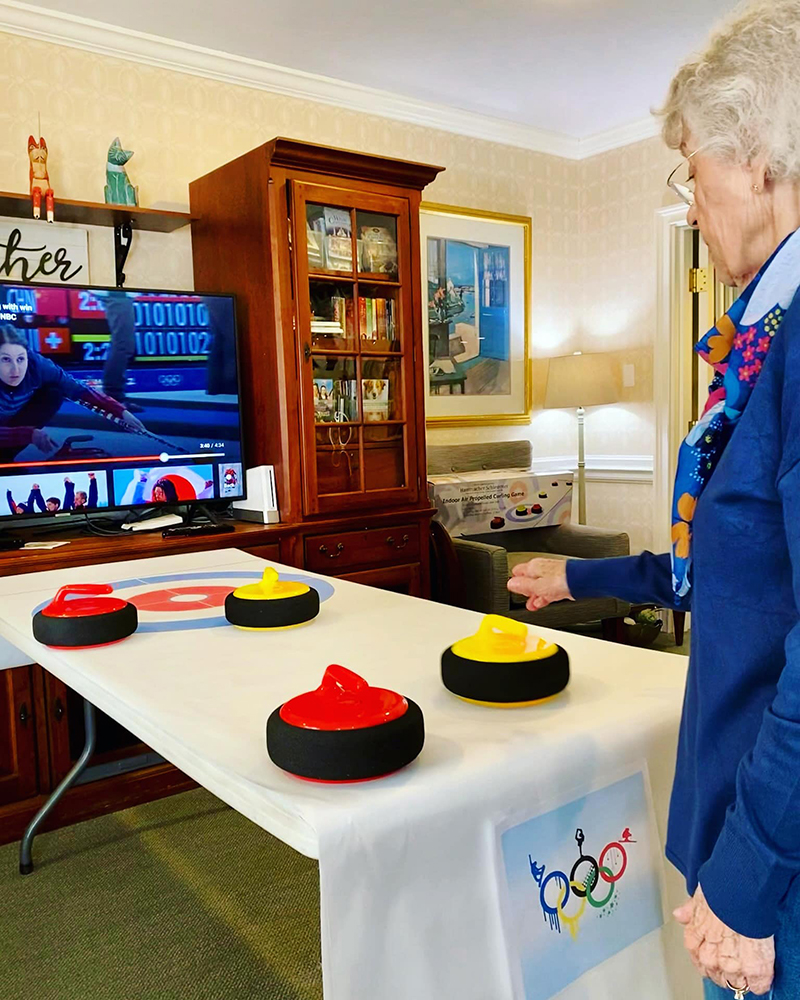 A senior resident playing curling inside the activity room