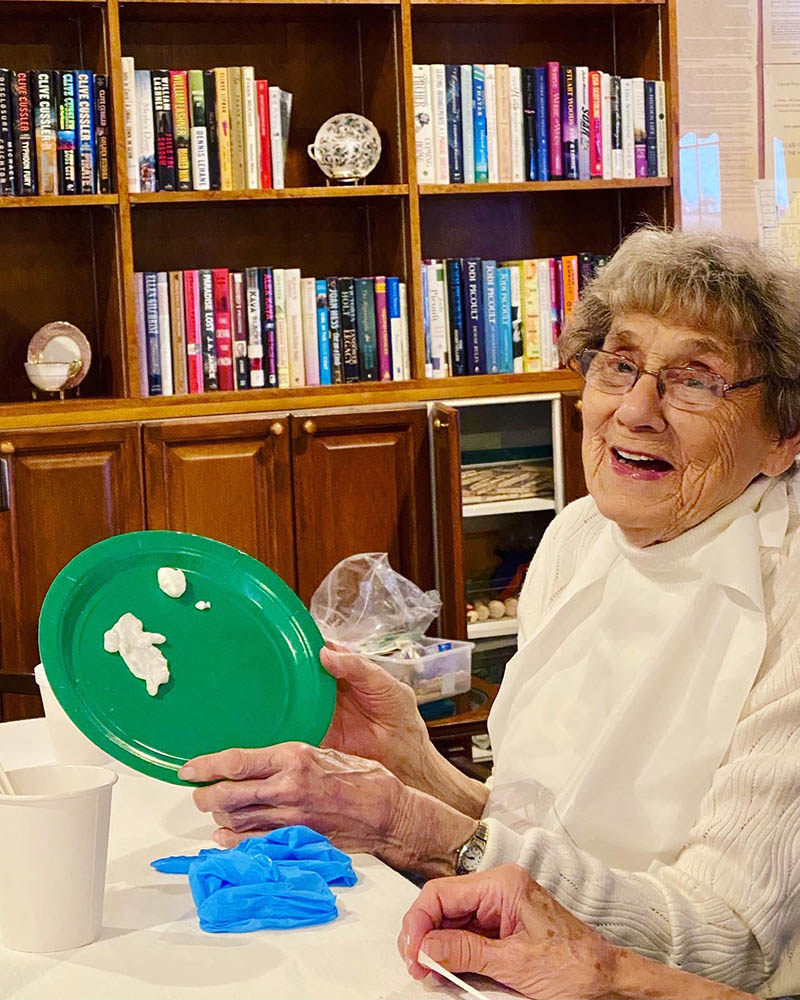 Senior resident enjoying an activity with a green plate
