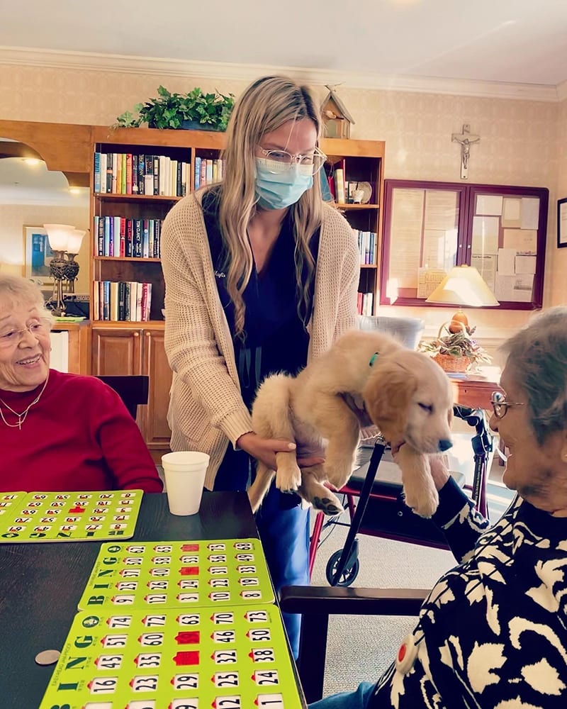 Residents enjoying bingo with a puppy