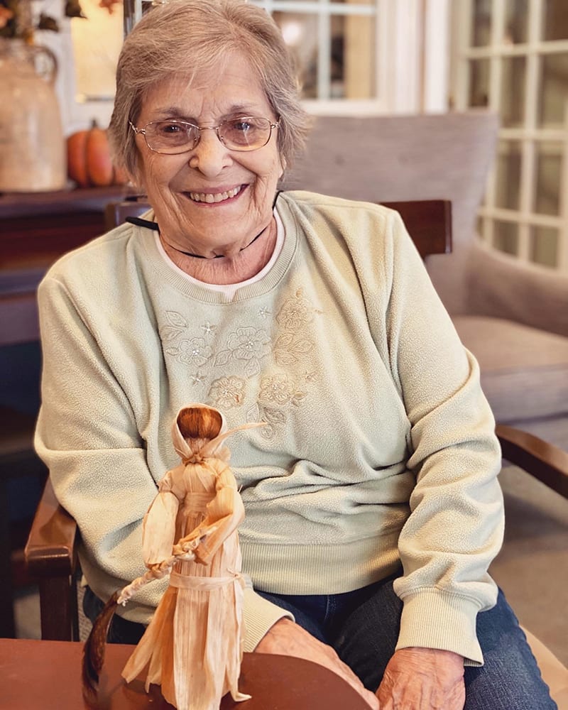 Happy resident sitting with a decorative figure