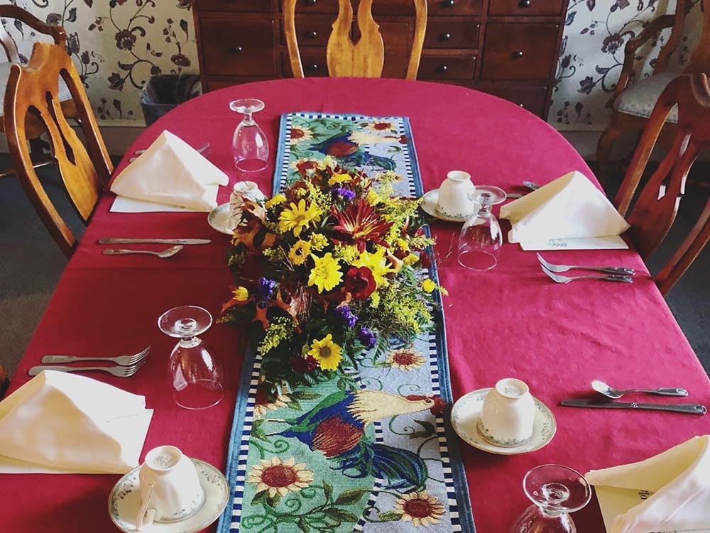 Dining table set for a meal with floral centerpiece
