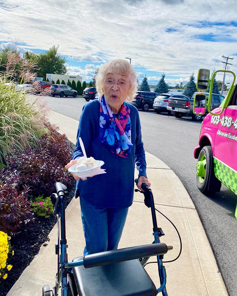 Resident enjoying ice cream outside on a walker