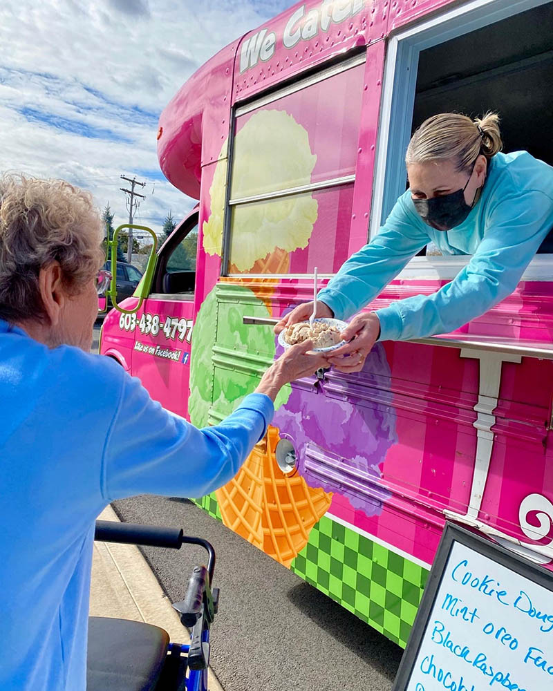 A resident receiving ice cream from a staff member