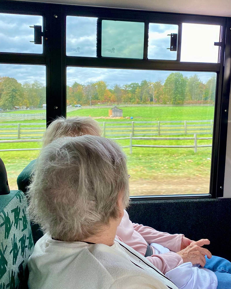 Two residents on a facility shuttle enjoying the view