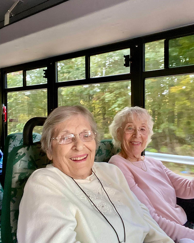 Two smiling residents enjoying a bus ride