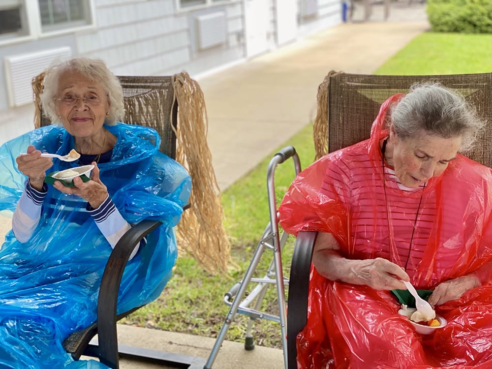 Two elderly women enjoying ice cream outside