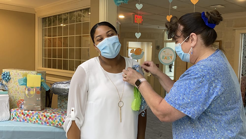 Staff member pinning a badge on a smiling resident