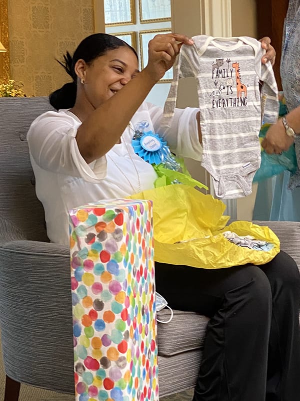 Staff member celebrates with a gift in a warm interior setting