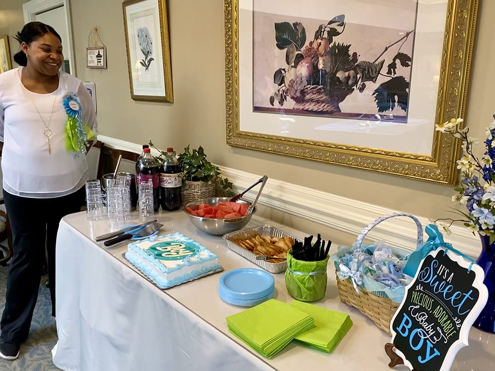 Staff member with a dessert table setup for a celebration