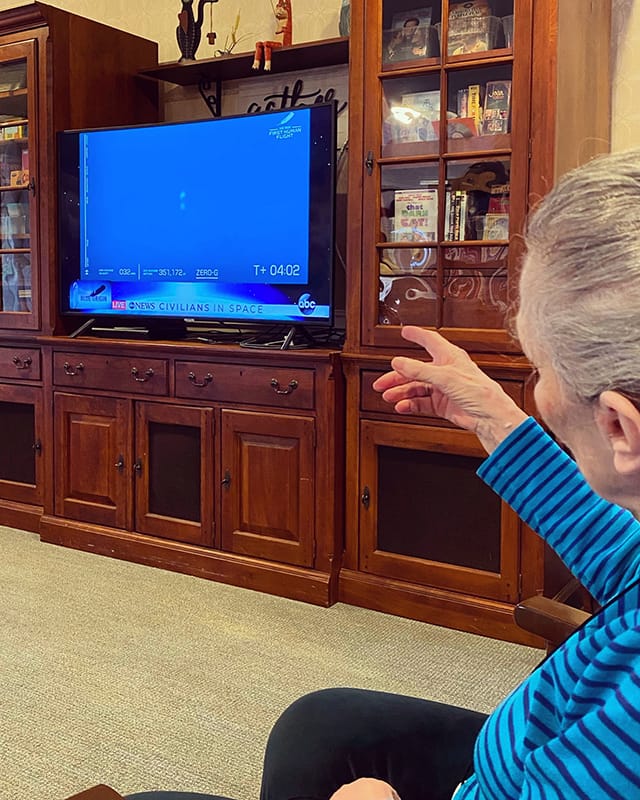 Resident watching television in a cozy common area