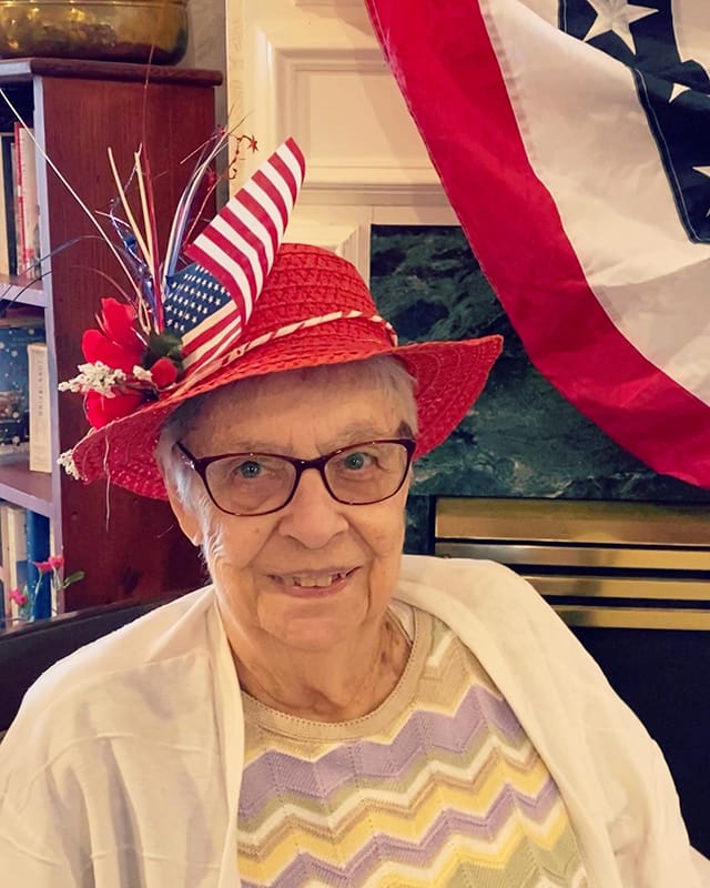 Resident wearing a festive hat, smiling