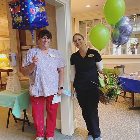 Staff celebrating with balloons in a common area