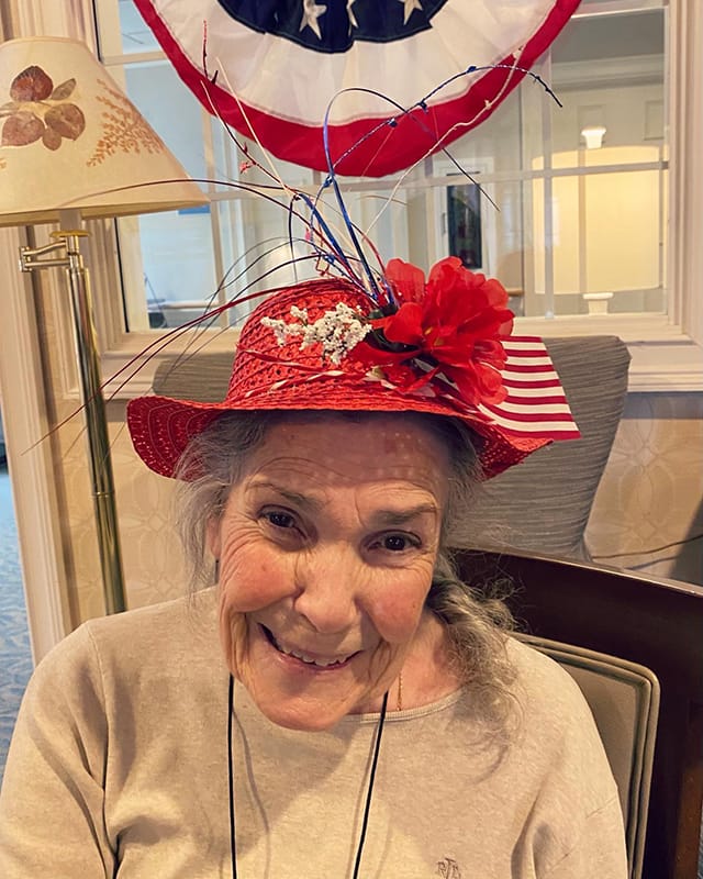 Resident smiling in a festive hat indoors