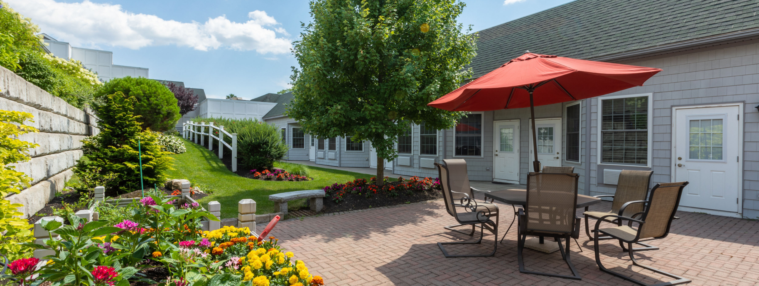 Outdoor patio area with table, chairs, and flowers