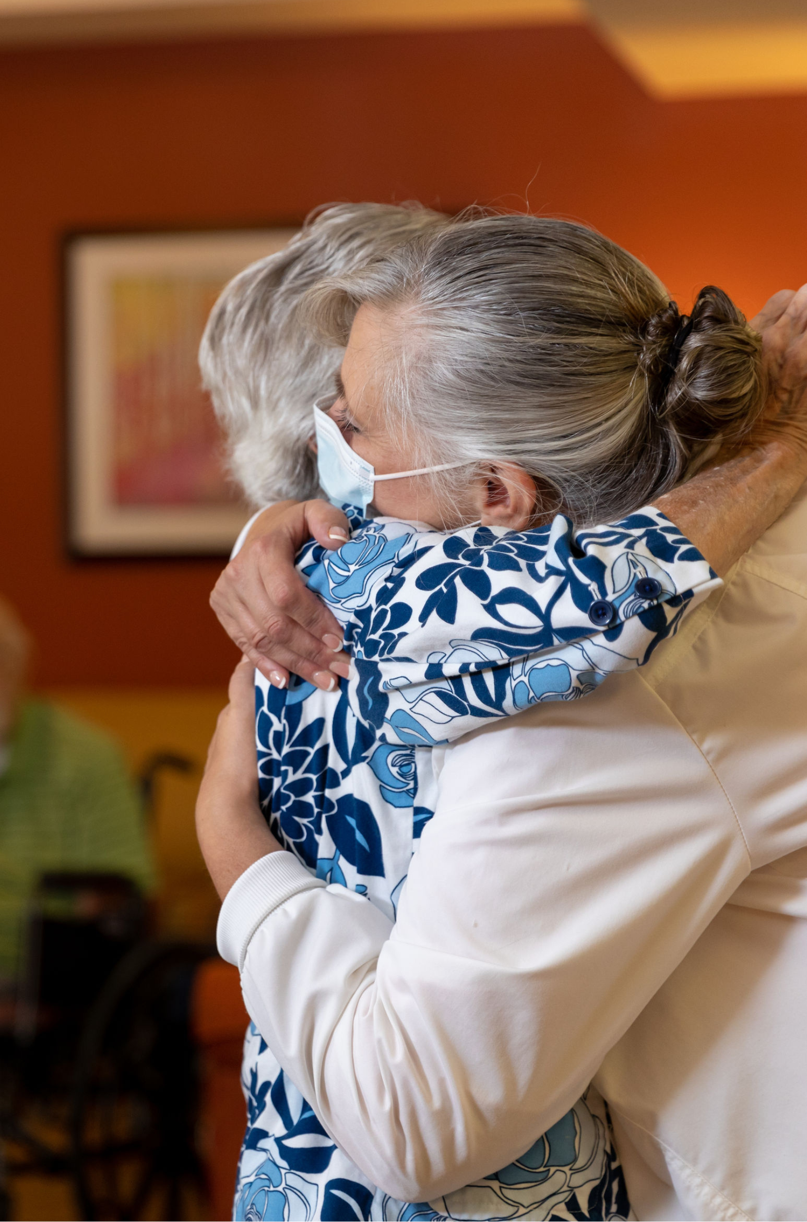 Residents embracing in a warm indoor activity space
