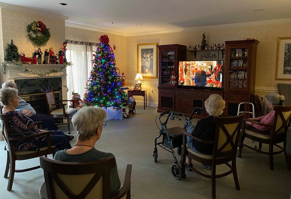 Residents enjoying a holiday movie in the common area