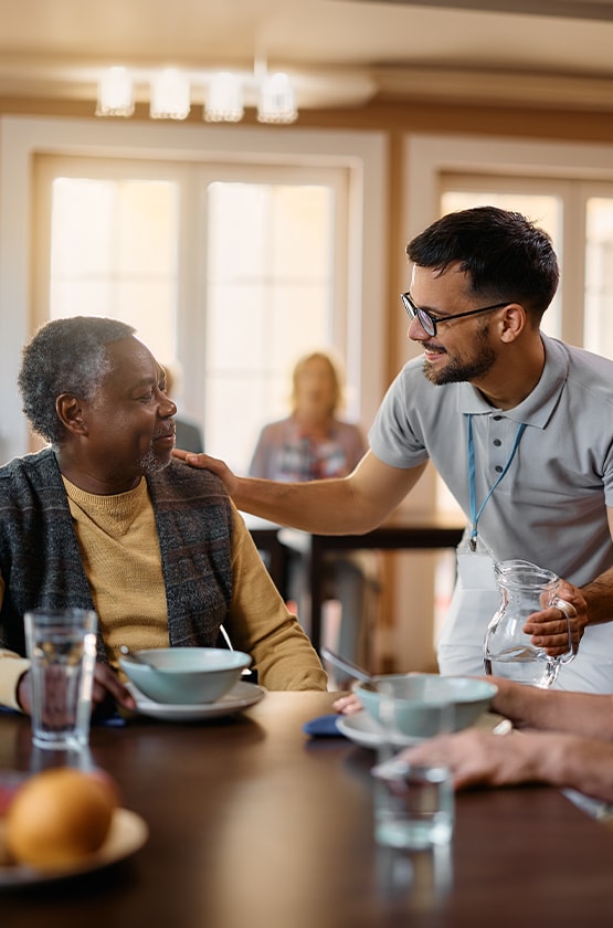 Staff serving food to a resident in the dining area