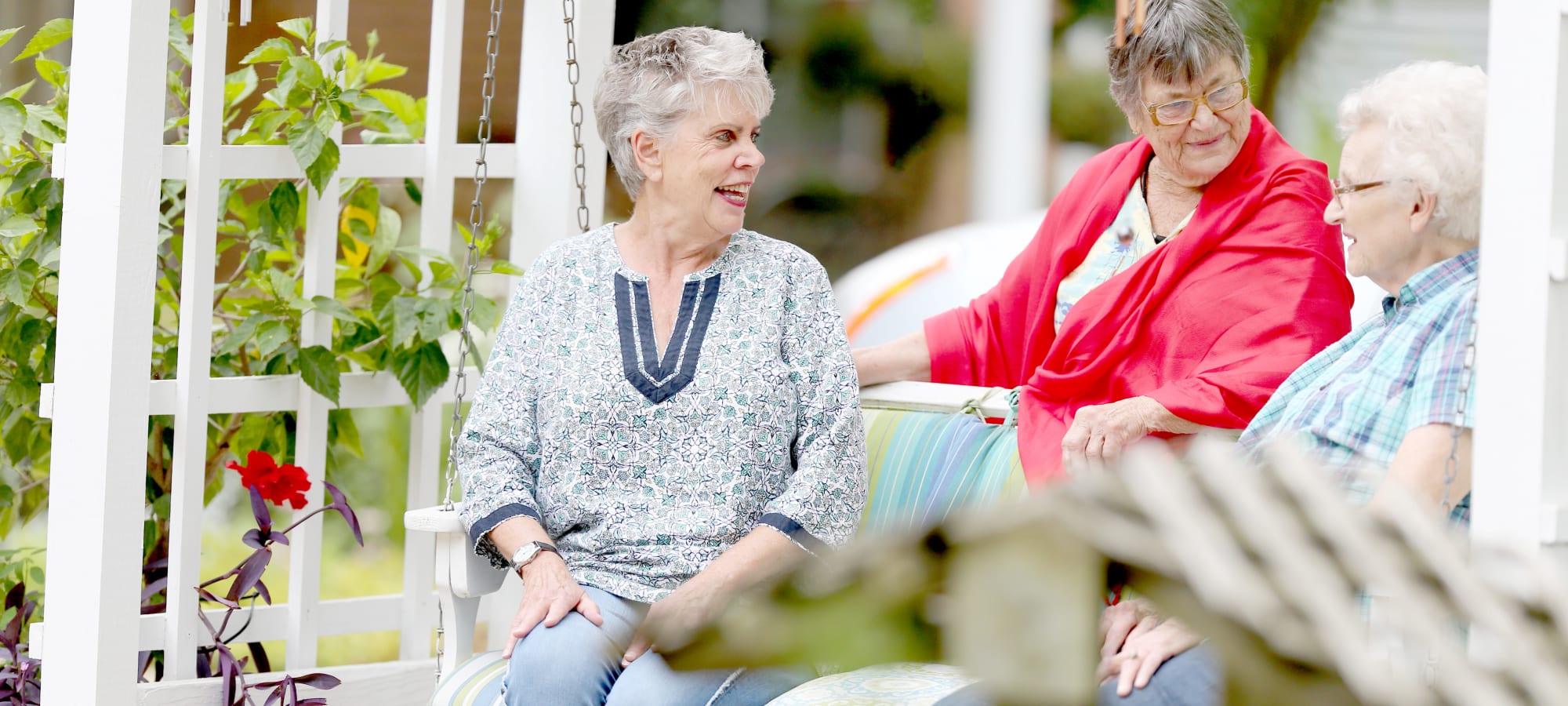 Residents enjoying conversation on a swing in a garden