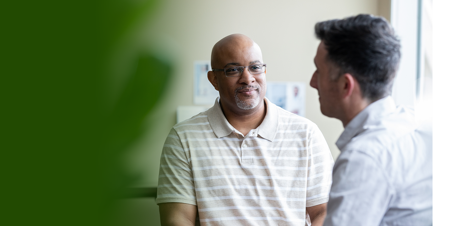 Two residents engaged in conversation in a bright interior space.