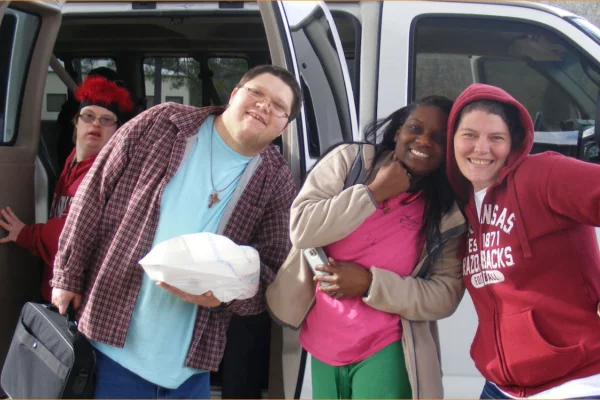 Residents and staff in front of a van
