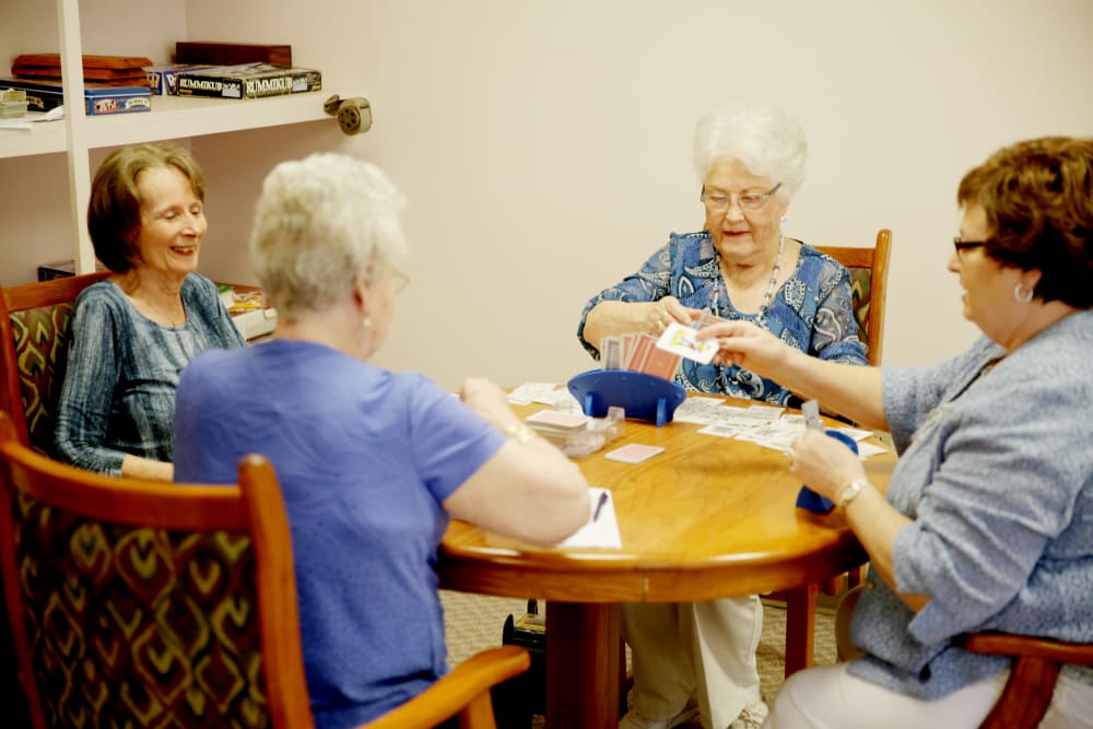 Residents enjoying a card game at a round table