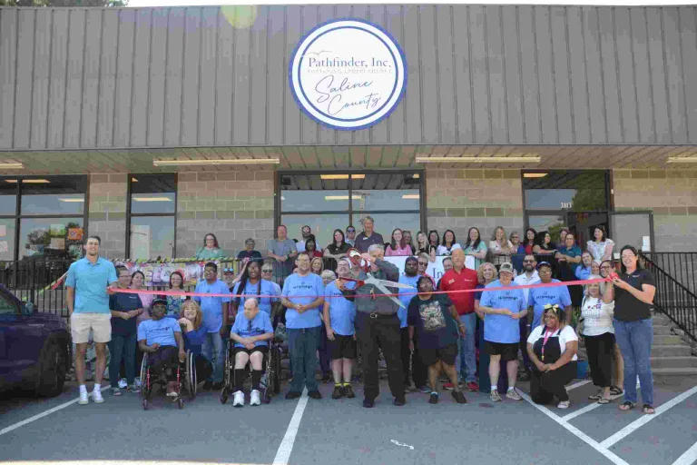 Group photo of residents and staff celebrating outside the facility