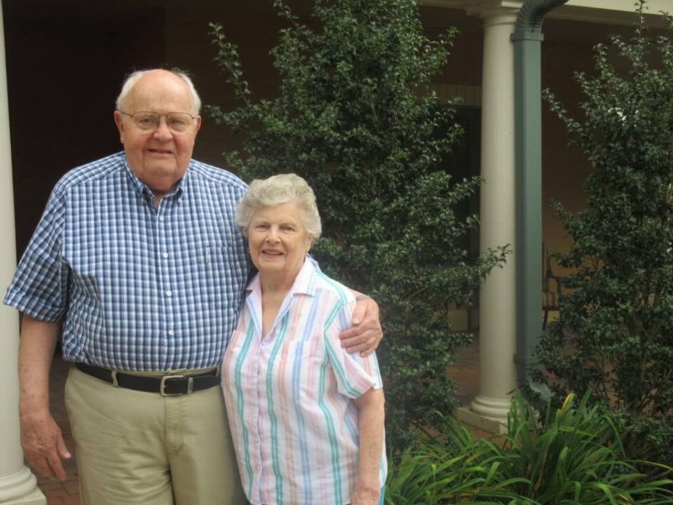 A couple posing together in a garden area