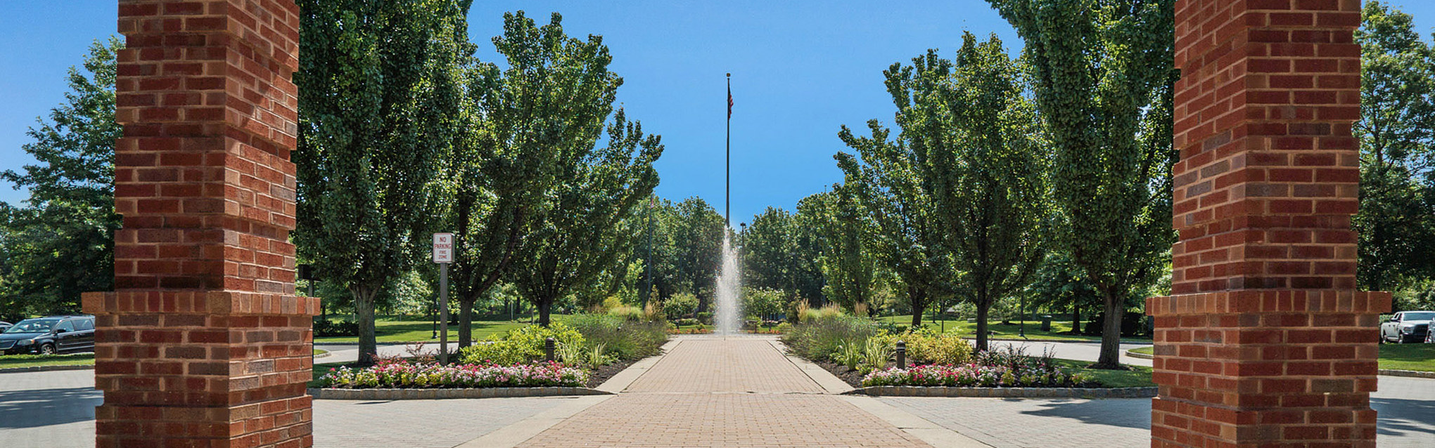 Pathway with trees and fountain in a landscaped area