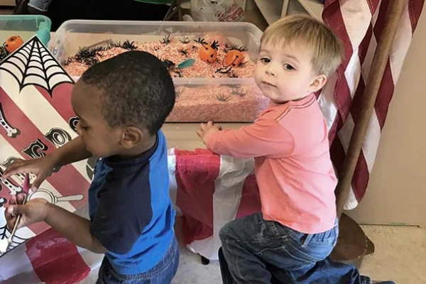 Two children playing near a decorated table