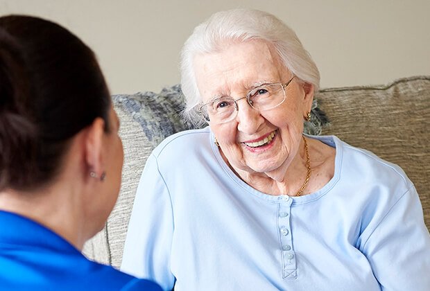 A smiling resident enjoying a conversation with staff