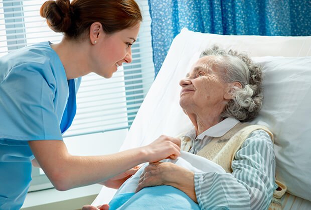 A caregiver interacting with a resident in a bright room