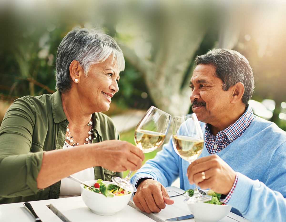 Couple toasting with wine glasses at an outdoor table