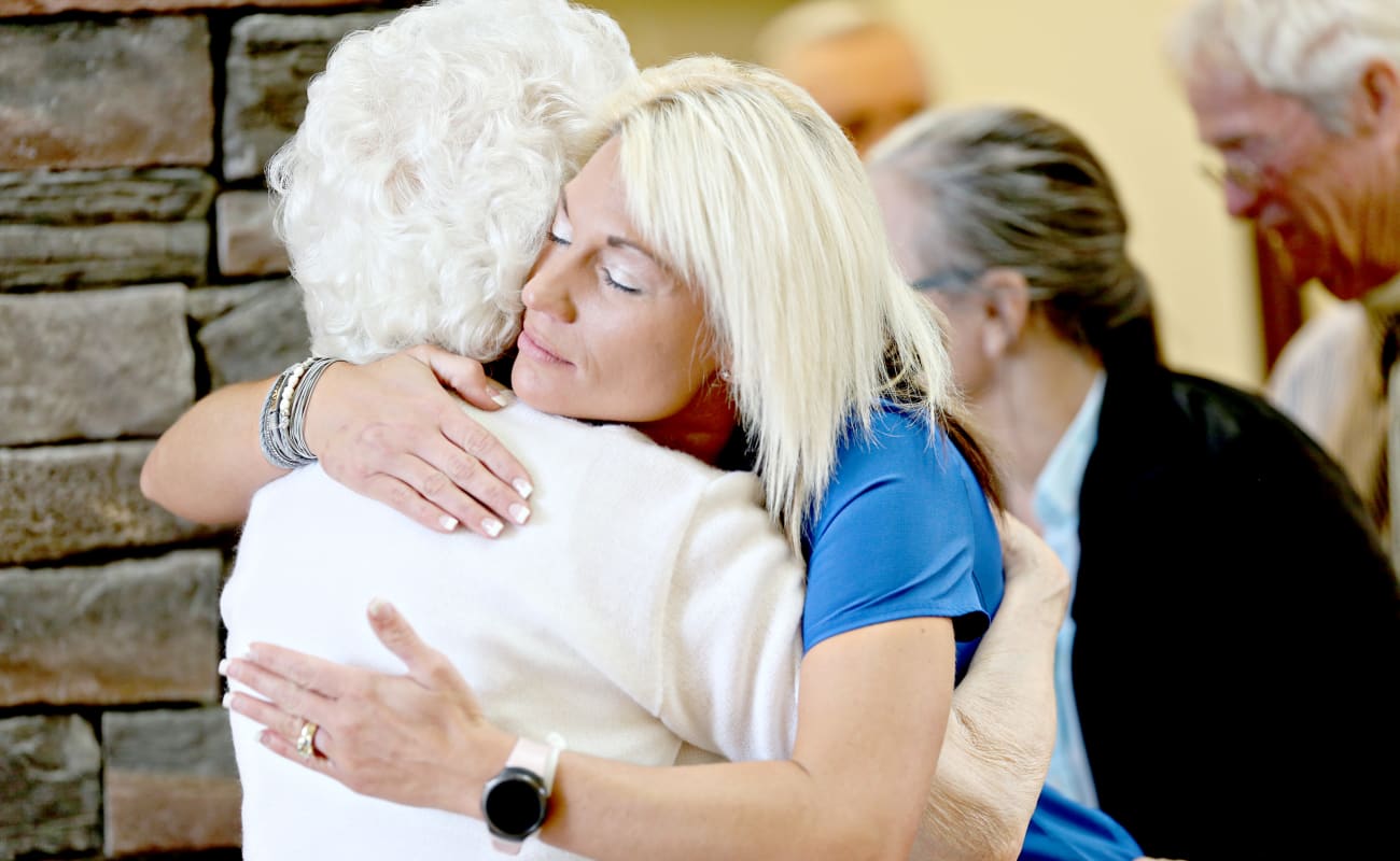 A caregiver hugging a resident affectionately