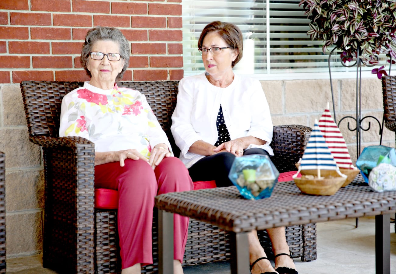 Two residents seated outside in a relaxed setting