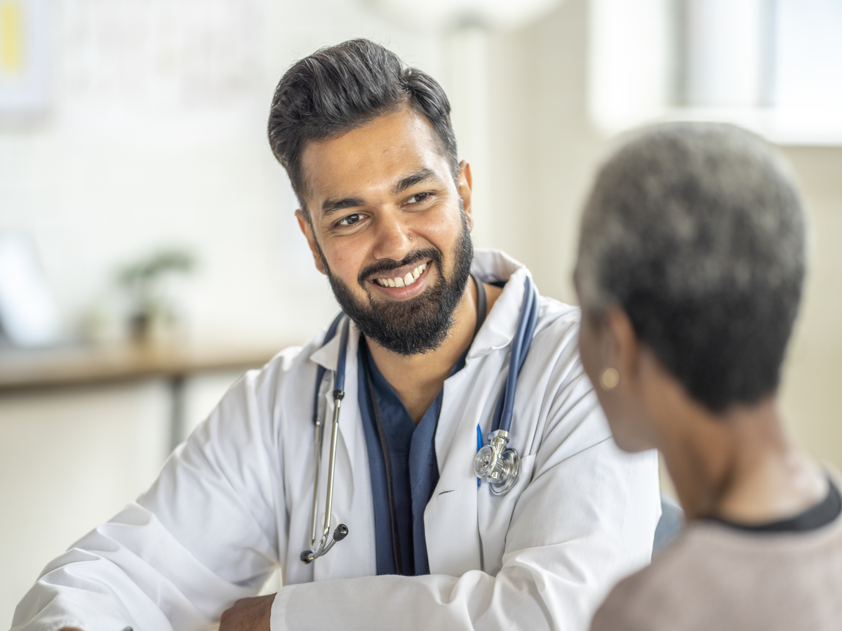 A doctor smiling and talking with a senior resident