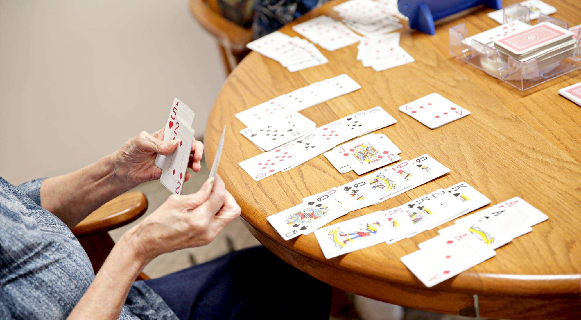 A resident playing cards at a wooden table